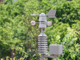 Fototapeta Londyn - Weather vane marking the direction of the wind and anemometer (wind speed meter) blurred by the action of the air located on top of a weather station