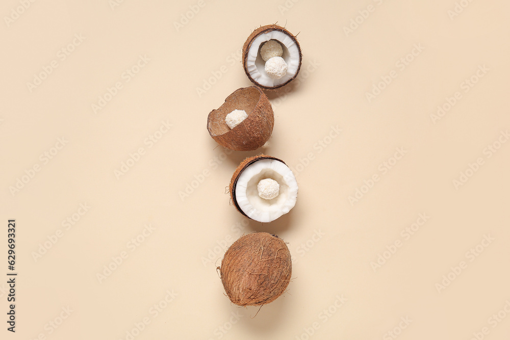 Coconuts with white chocolate candies on beige background