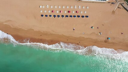 Wall Mural - Straight down aerial footage of the beautiful beach front of Albufeira in Portugal, showing the Praia do Inatel Beach and the waves crashing on the golden sandy beaches on a sunny summers day.