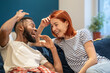 © DimaBerlin - Happy interracial couple man and woman talking laughing while sitting on sofa together, young family husband and wife bonding at home, spending time with each other, relaxing in living room
