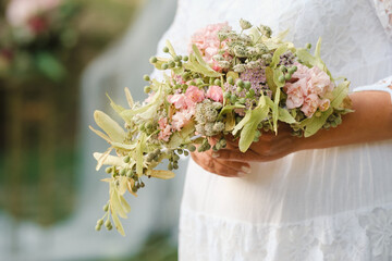 Wall Mural - The bride holds her wedding bouquet in her hands