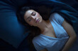 © Ai Studio - Top view of young woman sleeping on side at night, dreaming at home with blue blanket. High angle view of woman asleep with closed eyes.