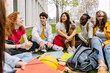 canvas print picture - Student friendship concept with multiracial classmate friends sitting together on the grass at campus college park. Millennial people having fun social gathering outside. Youth and education.