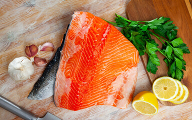 Wall Mural - Raw salmon fillet on wooden table with lemon and parsley