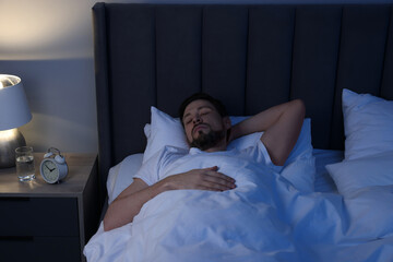 Wall Mural - Handsome man sleeping in bed at night