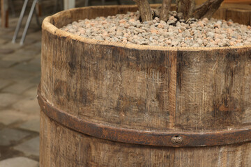 Wall Mural - Traditional wooden barrel with gravel outdoors, closeup