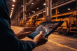 © Margo_Alexa - hands of a worker with a tablet on the background of a warehouse.