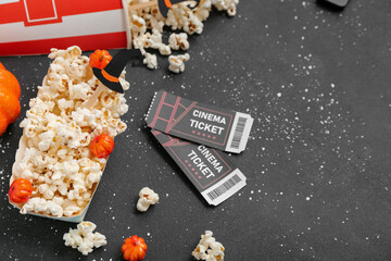 Sticker - Paper box with tasty popcorn and cinema tickets on dark background, closeup. Halloween celebration