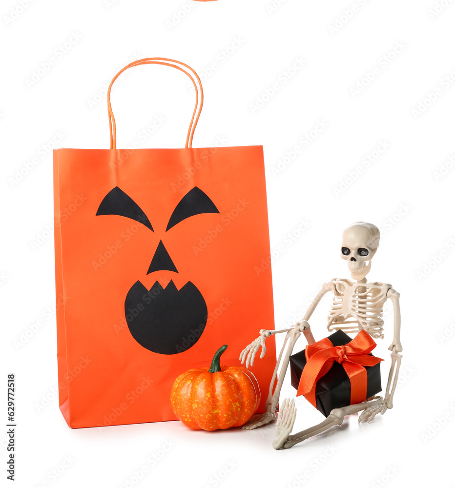 Orange shopping bag, skeleton, gift box and pumpkin for Halloween on white background