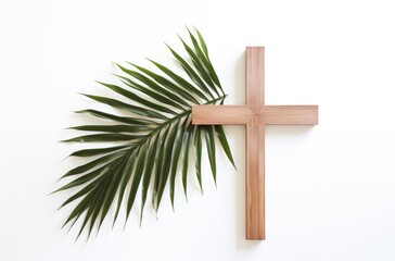 Wall Mural - Palm Sunday. Wooden cross and palm leaf on white background with copy space.