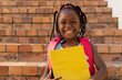 © WavebreakMediaMicro - Portrait of african american schoolgirl sitting on stairs and holding books at elementary school