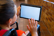 © WavebreakMediaMicro - Caucasian schoolgirl sitting in wheelchair and using tablet with copy space at school corridor