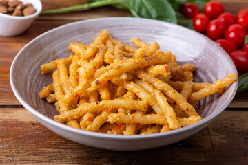 Wall Mural - Sicilian pasta Busiate with almond and tomatoes pesto. Typical Italian food from Sicily, pasta with red pesto.