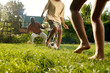 © pressmaster - Barefoot children and their father playing footbal on green lawn together and having fun on summer day on the countryside during vacation
