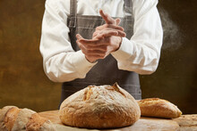Baker Cooking Bread. Man Slaps Flour Over The Dough. Men's Hands With Flour Clap.
