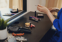 Woman Doing Makeup In Front Of A Mirror At Home.