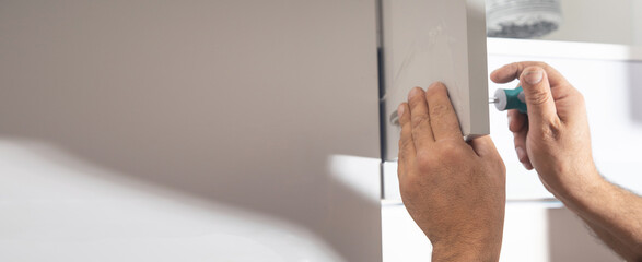 Wall Mural -  Worker fixing kitchen cabinet using screwdriver.