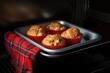 oven mitts holding a baked muffin tray
