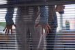 © Seventyfour - Workplace harassment close up with man pushing woman against glass wall in office, focus on female hands