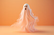 © marialr - A Halloween ghost isolated on a light pastel peach background