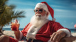 Santa Claus in red suit with cocktail on beach near ocean.