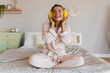 © mary_markevich - smiling woman relaxing at home on bed in morning in pajamas listening to music