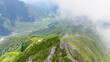 ガスが湧き立つ初夏の西穂独標に集う登山者たちを上高地を背景に上空から空撮