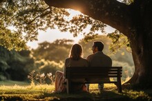 Couple Sitting On A Bench At Sunset
