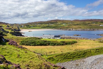 Canvas Print - Tranquil Clashnessie Bay surrounded by rocks and lush green grass in Scotland