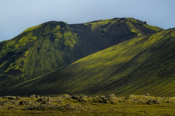 scenic landscape featuring a mountain range covered in lush green grass, iceland