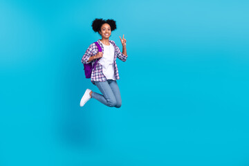 Poster - Full length photo of sweet shiny girl dressed checkered shirt jumping showing v-sign going college isolated blue color background