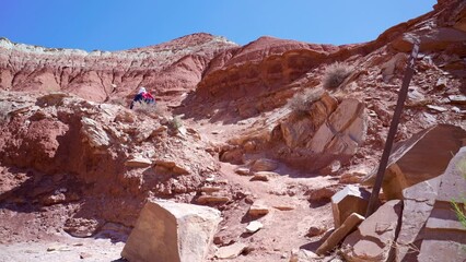 Poster - Person walking in the big canyon with deserted lands and big rocks on a hot sunny day