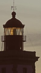 Wall Mural - lighthouse lighting in the twilight at sunset. vertical video