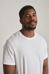Canvas Print - Minimal portrait of handsome black man posing against white vertical