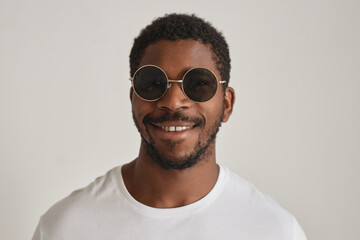 Wall Mural - Minimal front view portrait black man wearing sunglasses against white background