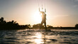 © Travel 'n' Lifestyle - Kitesurfer silhouette on the water against bright evening sun in Egypt.