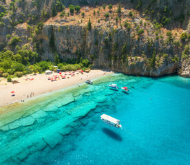 Canvas Print - Aerial view of sandy beach, blue sea, yacht and boat, rock, umbrellas at summer sunny day. Butterfly Valley in Oludeniz, Turkey. Top drone view of sea coast, swimming people, clear azure water. Travel