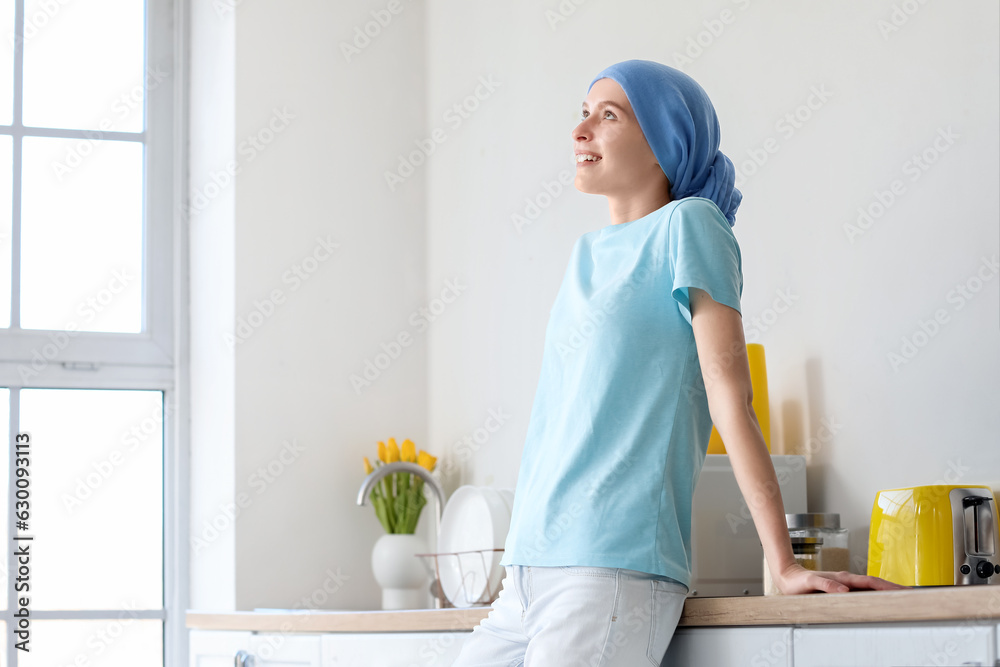 Teenage girl after chemotherapy in kitchen