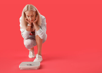 Poster - Sad mature woman with scales on red background