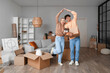 © Pixel-Shot - Young couple with house model in room on moving day
