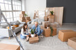 © Pixel-Shot - Young couple packing houseplant in room on moving day