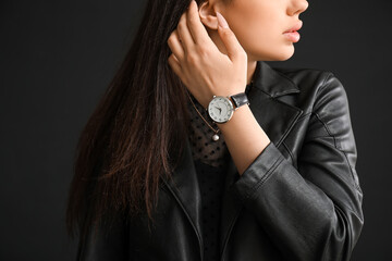 Sticker - Stylish beautiful woman with wristwatch on black background