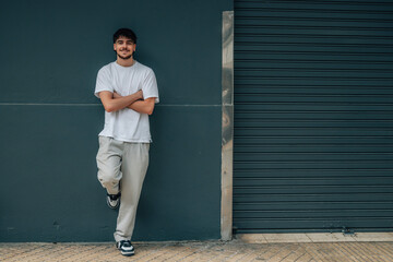 young man in the street leaning on the wall