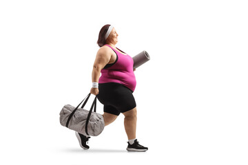 Sticker - Overweight young woman in sports clothing carrying a sports bag and walking