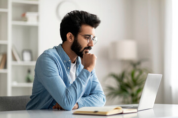 Aufkleber - Pensive Young Indian Male Freelancer In Eyeglasses Working With Laptop At Home