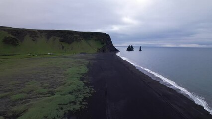 Wall Mural - DRONE AERIAL FOOTAGE: Reynisfjara Black sand beach, Halsanefshellir cave, basalt columns and sea stacks at Vik i Myrdal in Iceland.