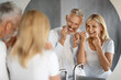 Morning Routine. Smiling Mature Couple Using Dental Floss In Bathroom Together