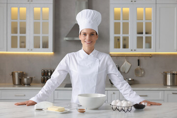 Wall Mural - Portrait of professional chef near table with ingredients in kitchen