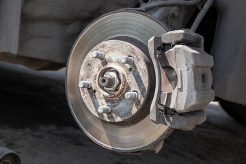 Poster - Disc brake of the vehicle for repair, in process of new tire replacement. Car brake repairing in garage. Replacement of brake pads. Suspension of car for maintenance brakes and shock absorber systems.