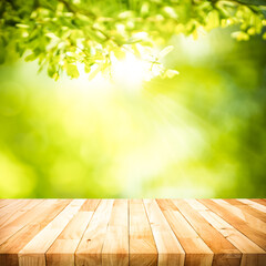 Wall Mural - selective focus.real wood table top texture on blur leaf tree garden background.For create product display or design key visual layout